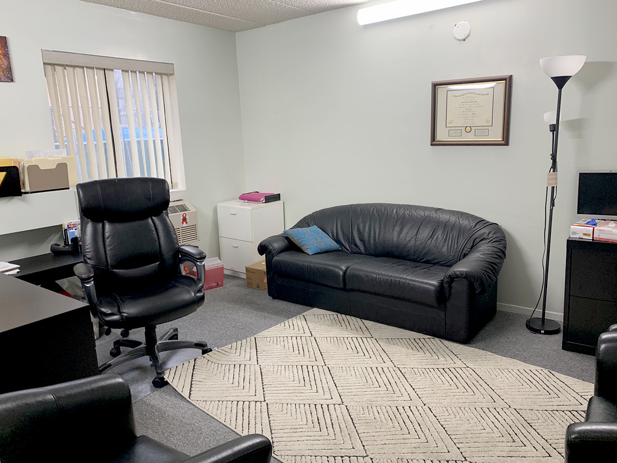 Living room area with couch, chairs, and framed picture