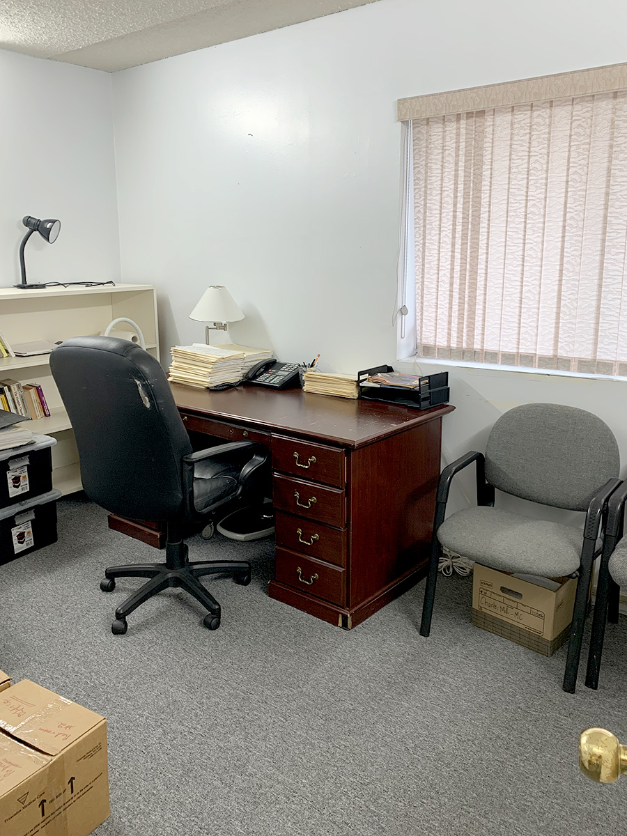 Office space featuring desk, chairs, and boxes