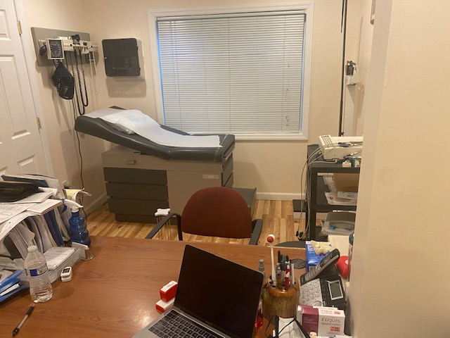 Office setting featuring a laptop, desk, and comfortable chair