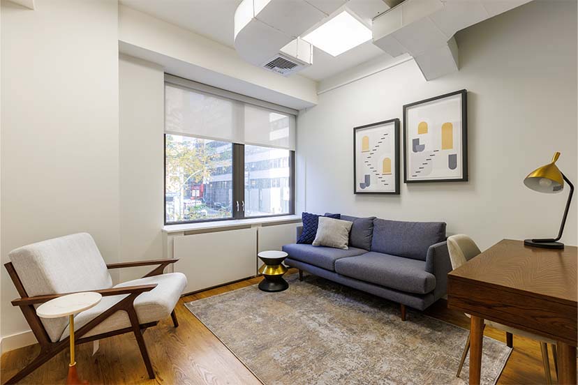 Living room area with couch, chairs, and decorative elements