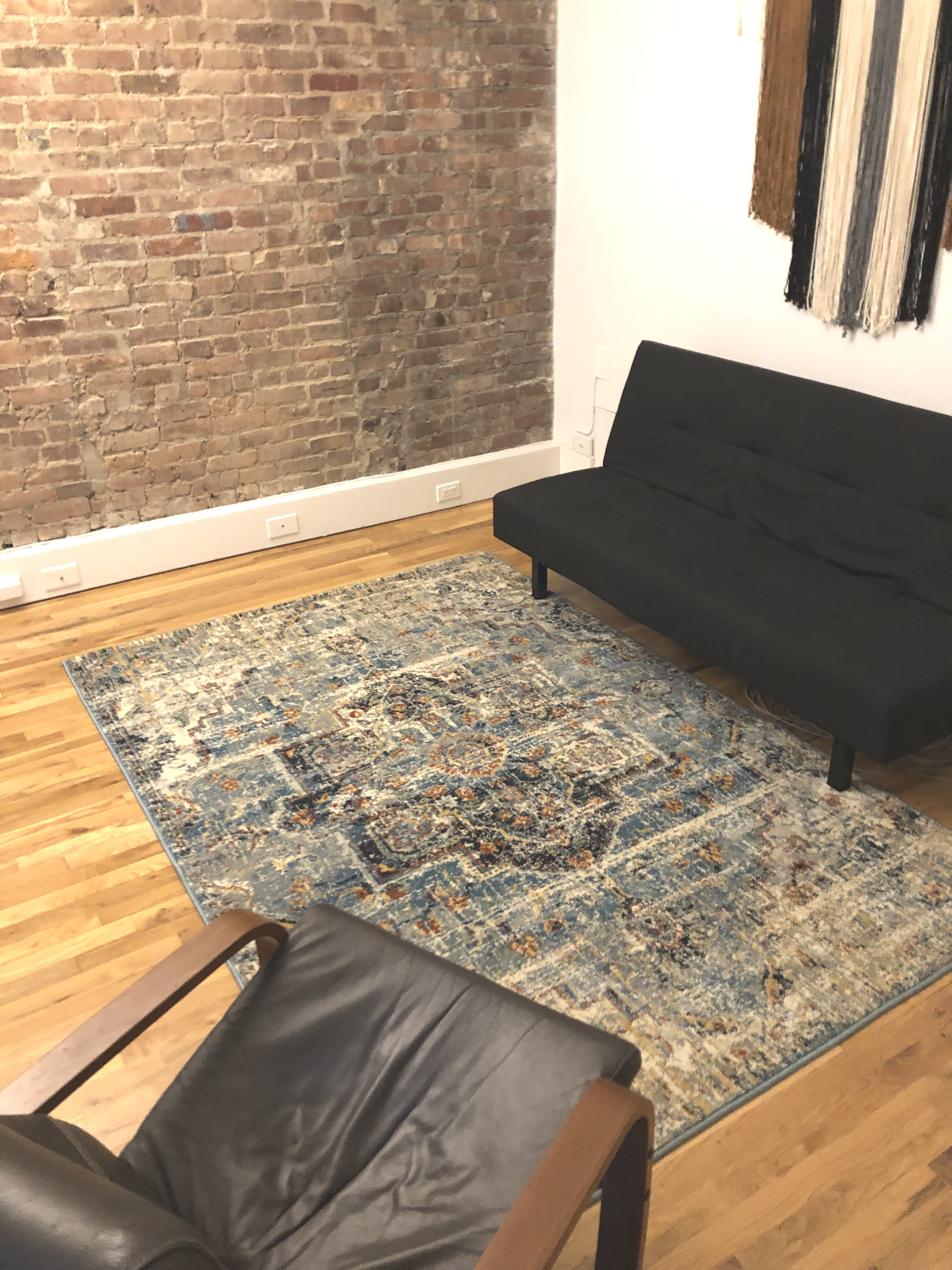 Office interior with couch, rug, and chairs arranged