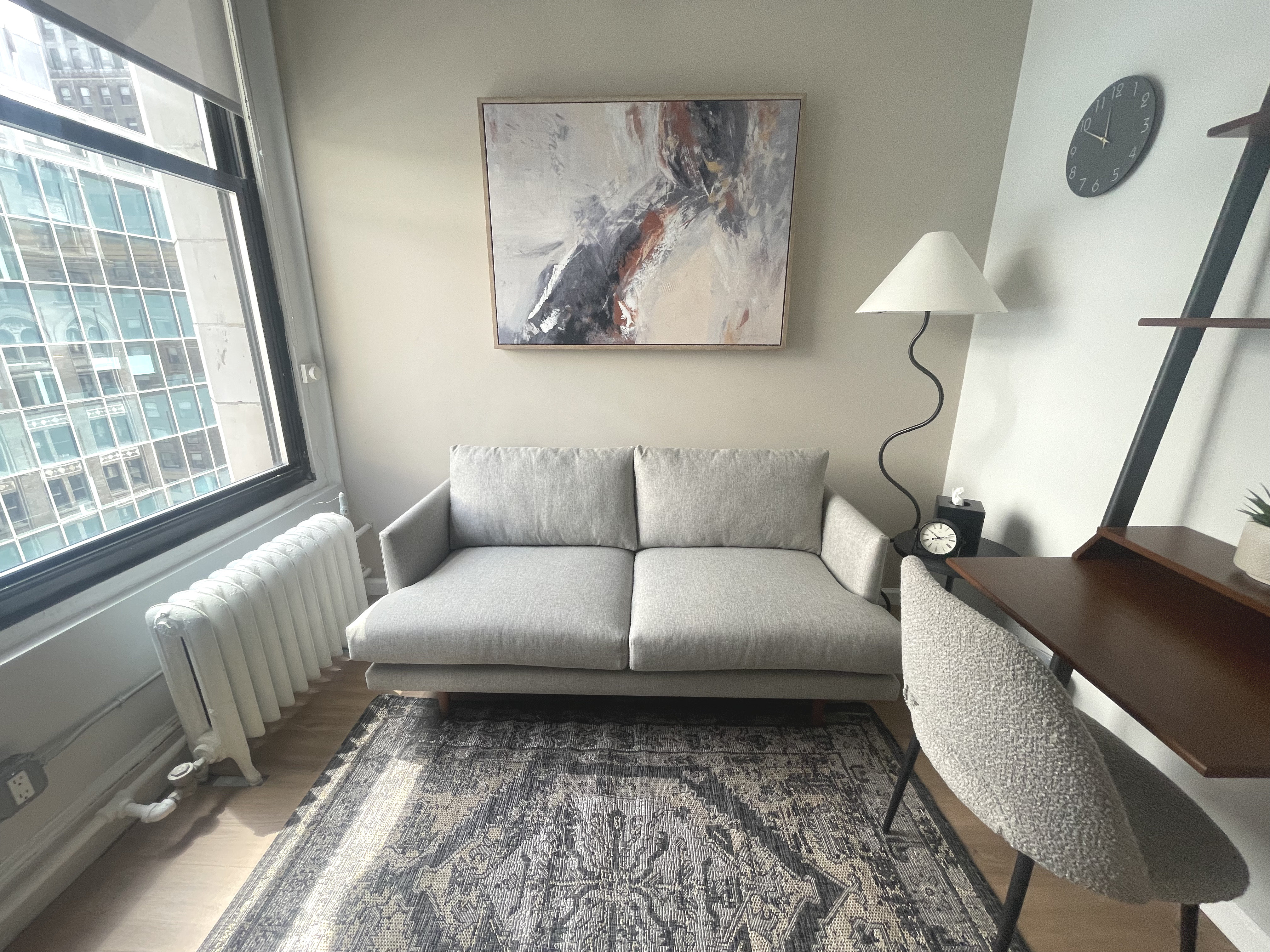 Living room style office with couch, table, and lamp