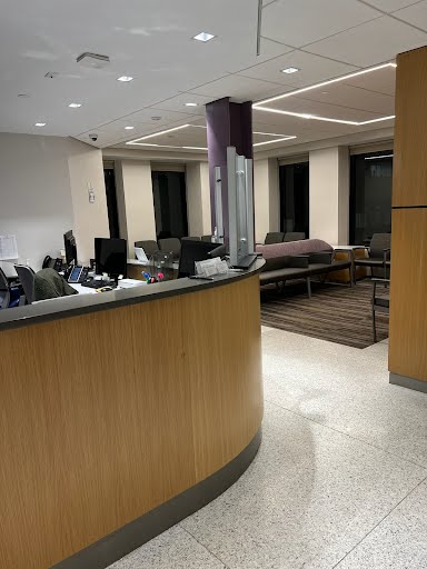 Reception area with chairs, table, and a monitor