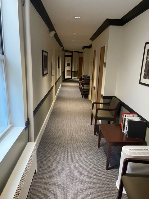 Interior hallway with chairs and artwork on the walls