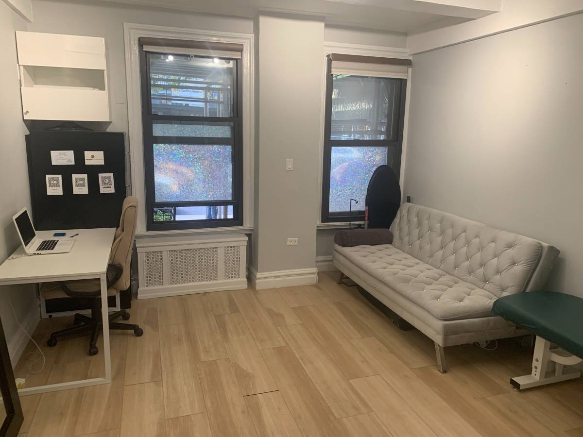 Office space with couch, table, and technology setup