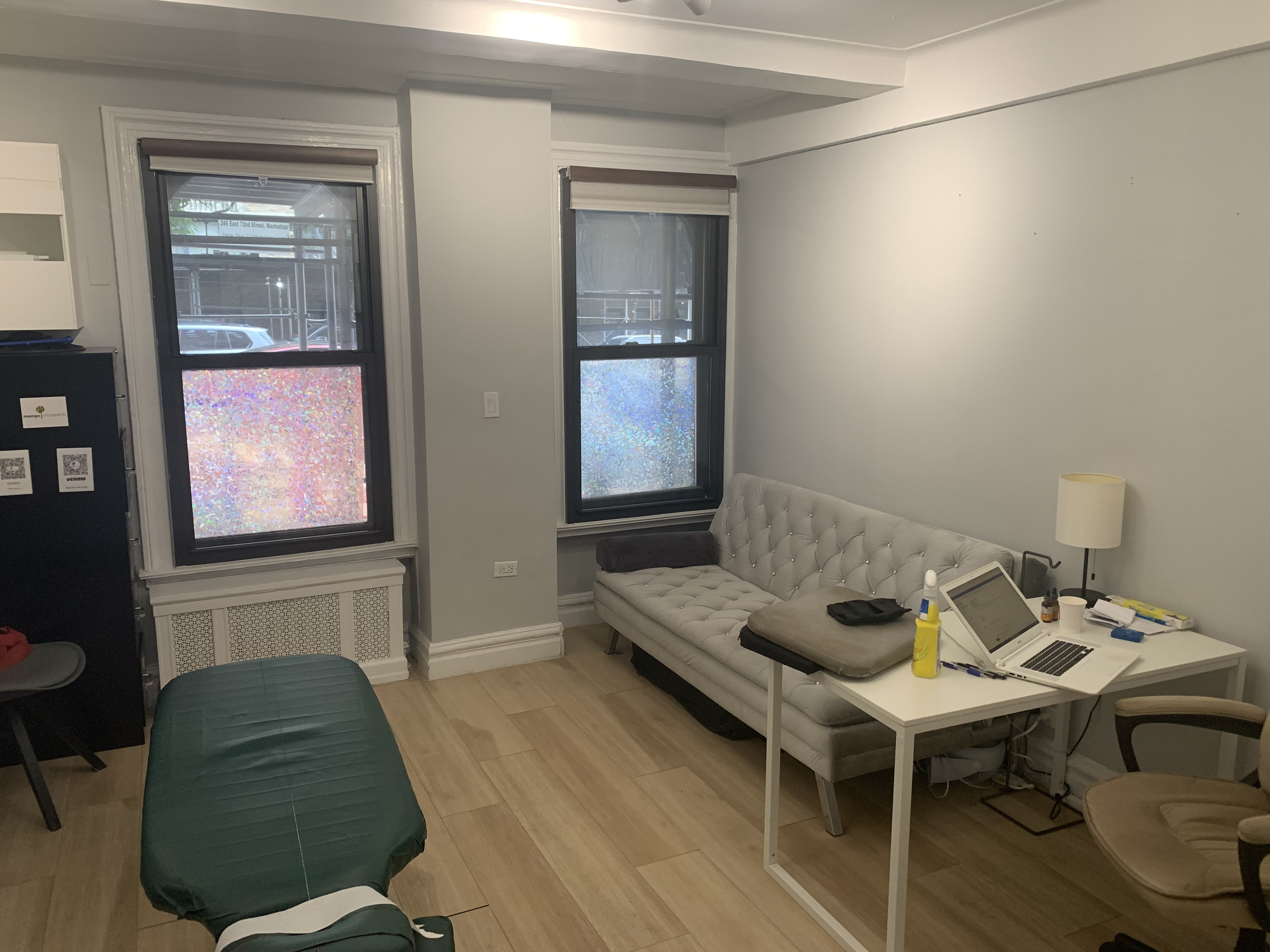 Living room-style office with couch, table, and laptop