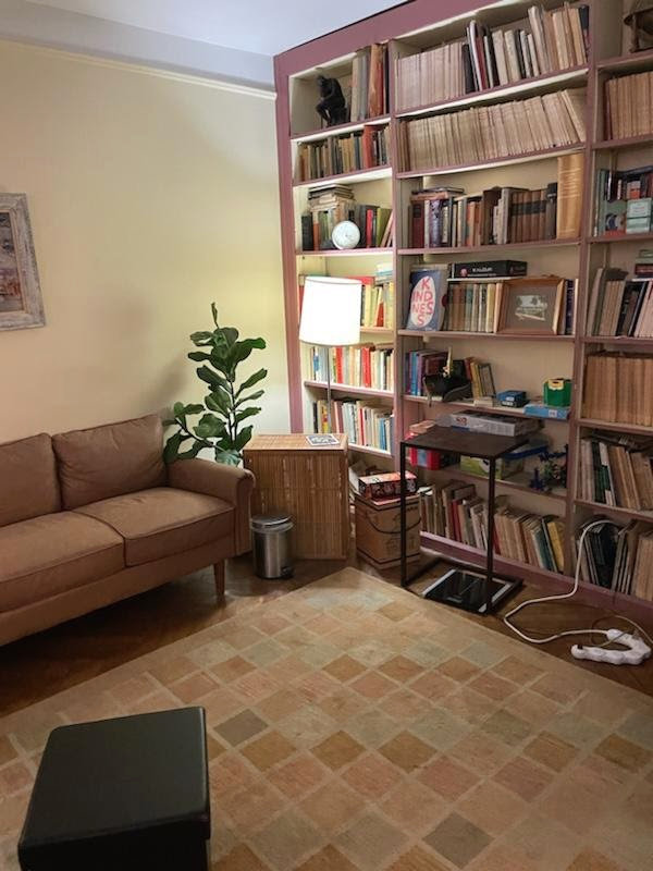 Cozy office featuring a couch and a bookcase