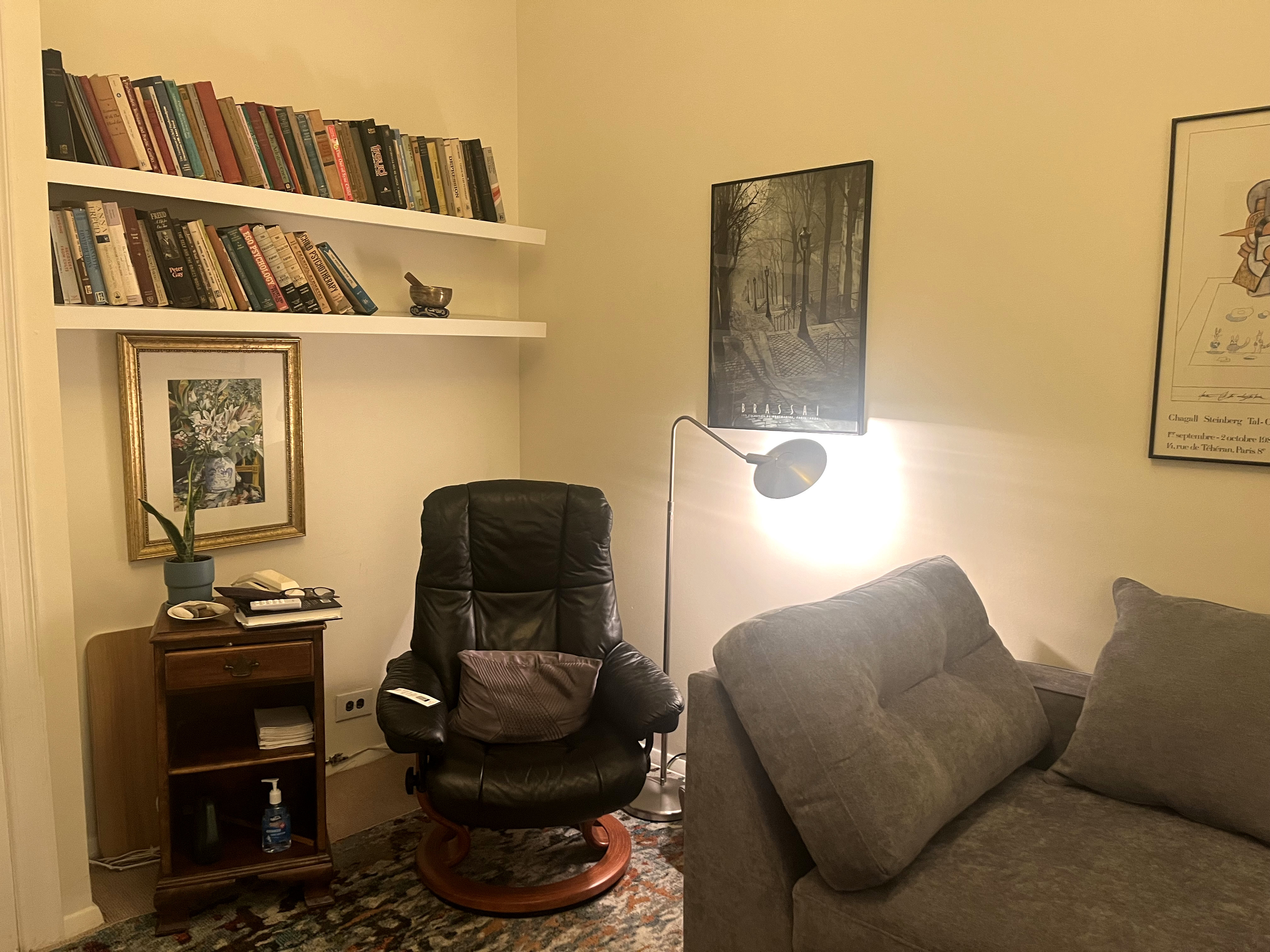 Living room-style office with couch, chairs, and bookshelf