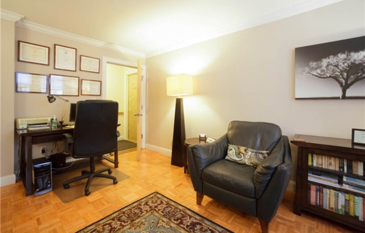 Cozy office interior featuring couch, desk, and lamp