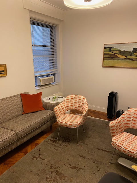 Living room area with couch, chairs, and decor