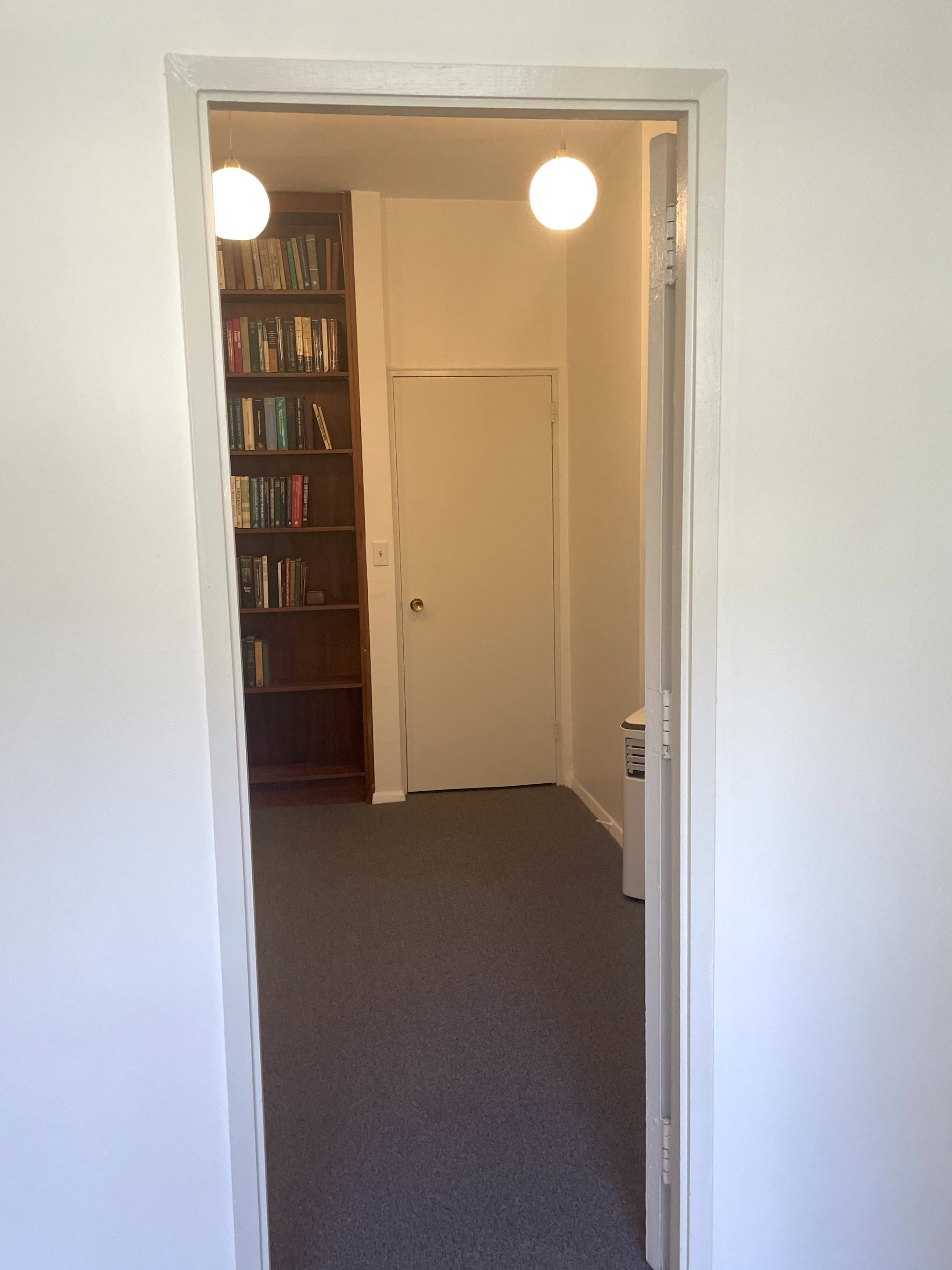 Office interior with wooden flooring, furniture, and lamp
