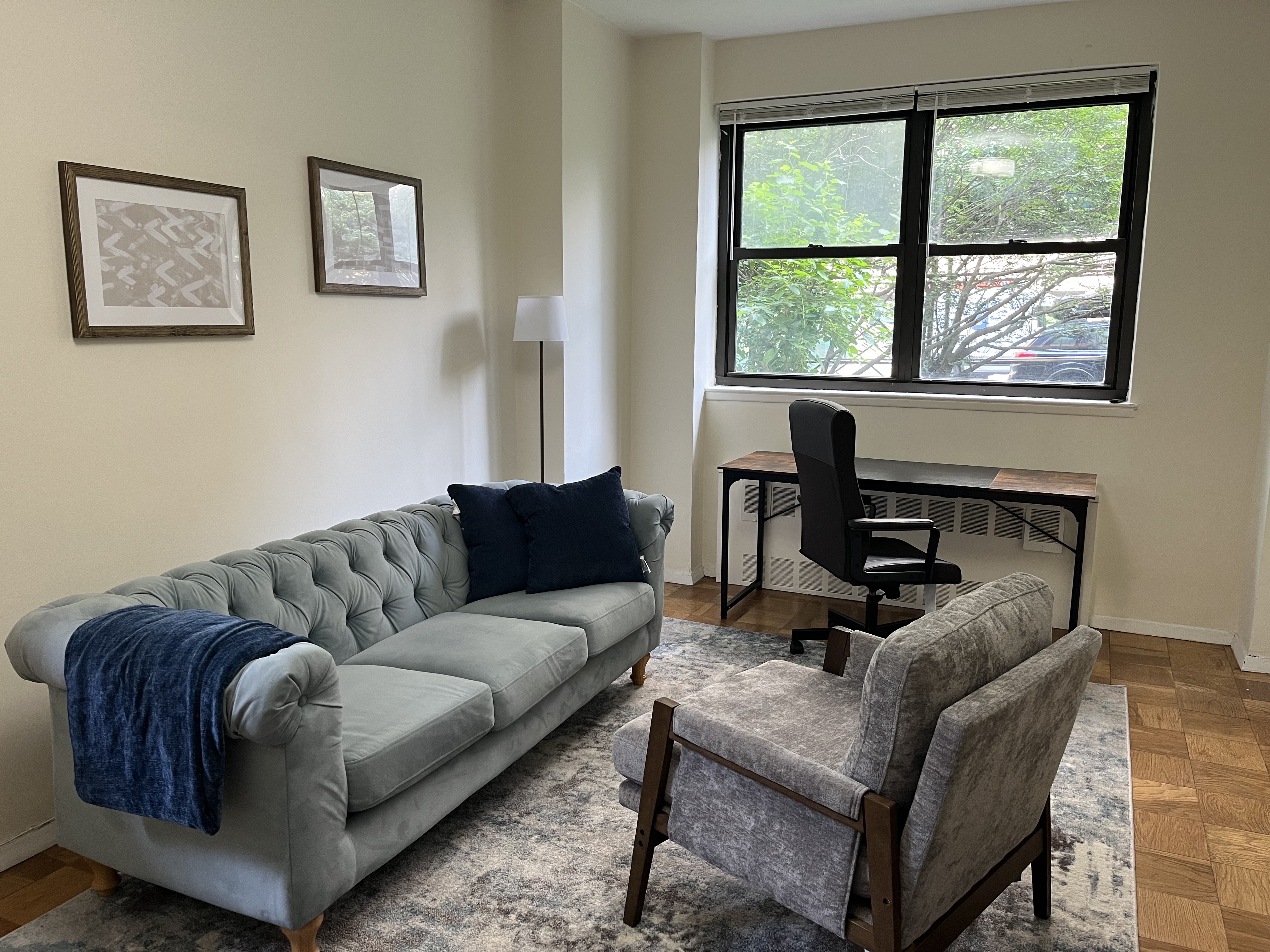 Office space featuring couch, desk, and decorative lamp