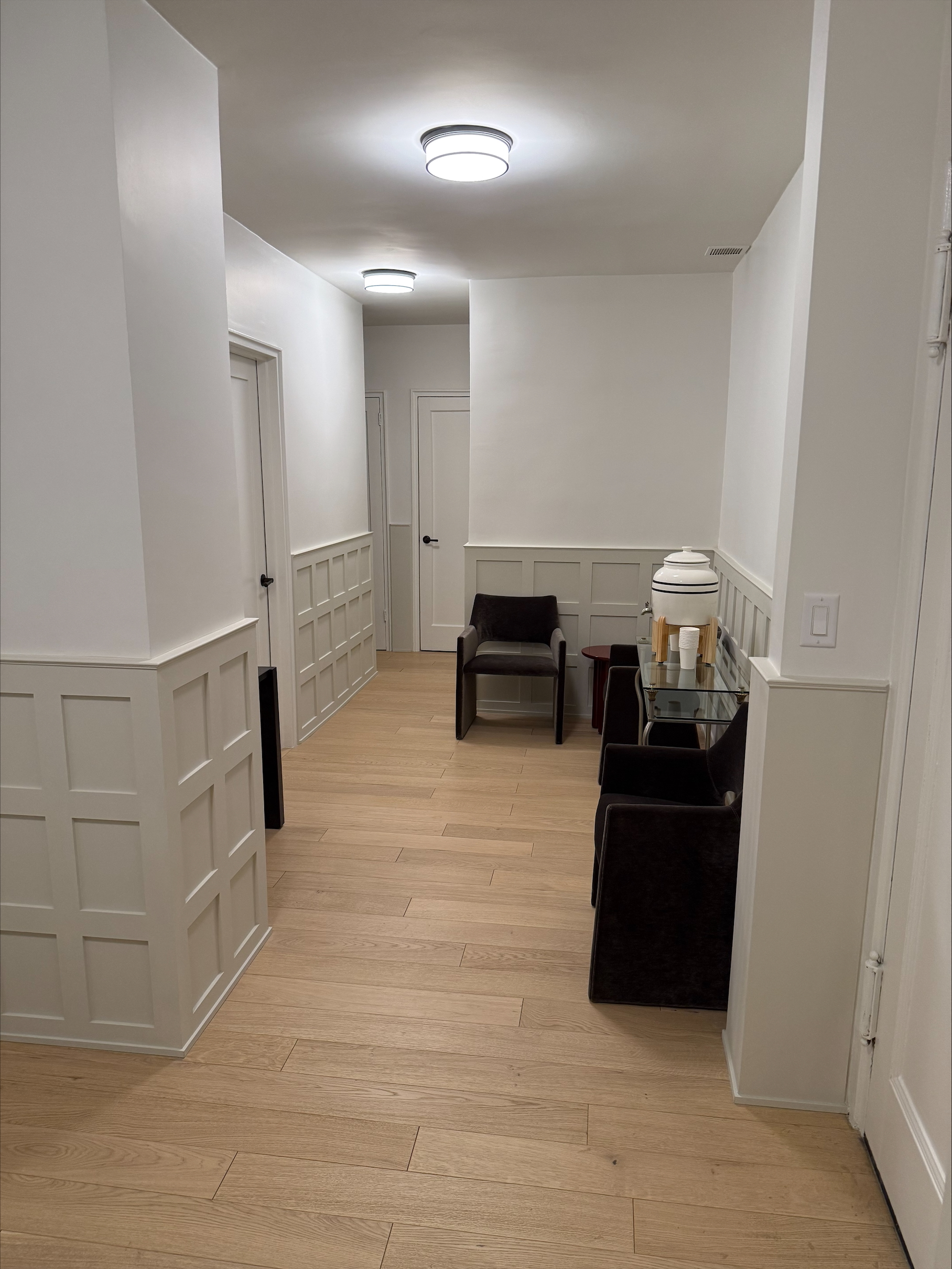 Foyer area with floors, chairs, and lamps